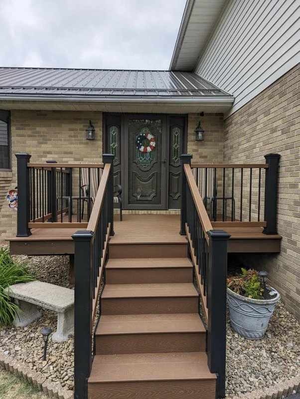 Front entry composite landing with black railing after upgrade